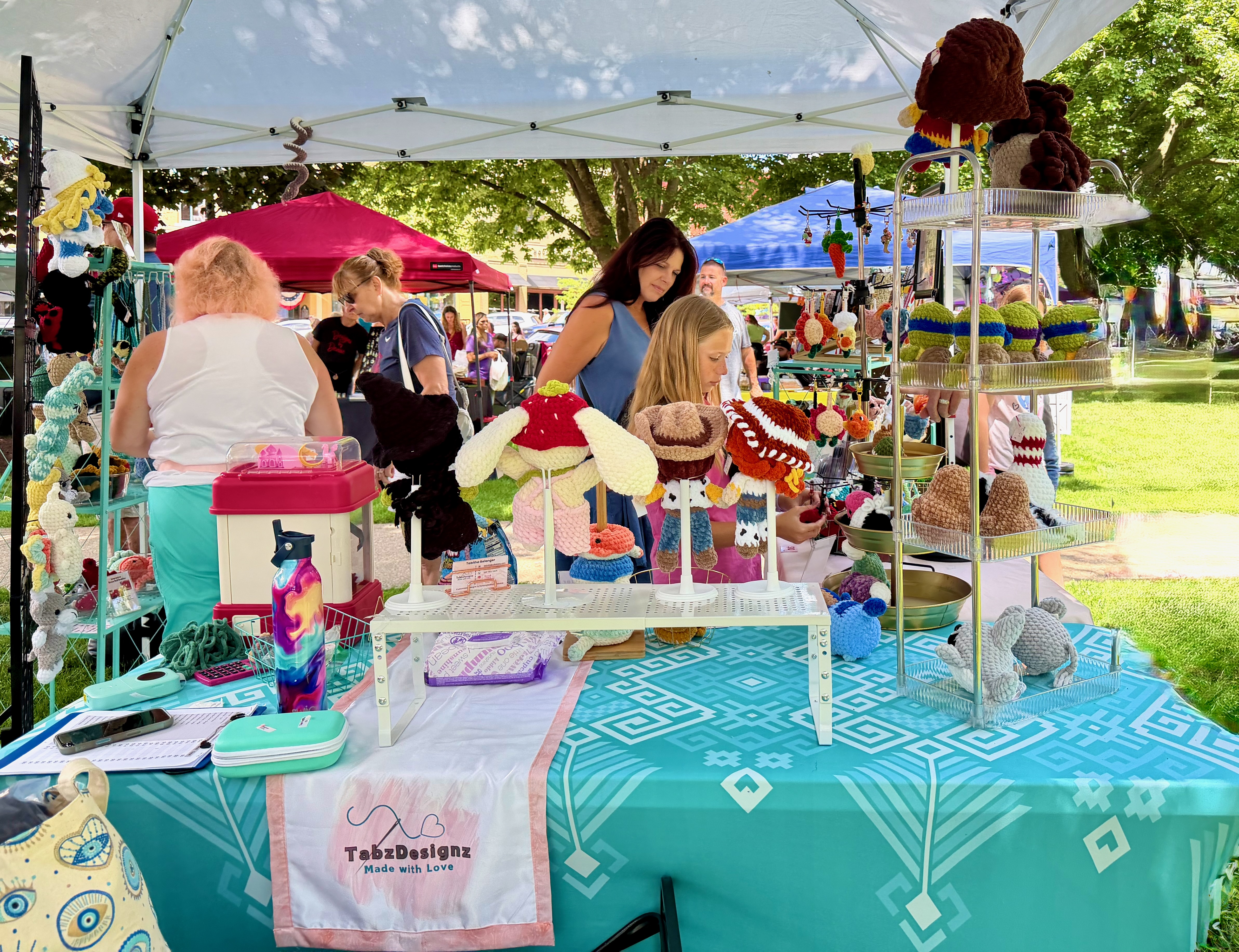 TabzDesignz booth with customers browsing crochet items